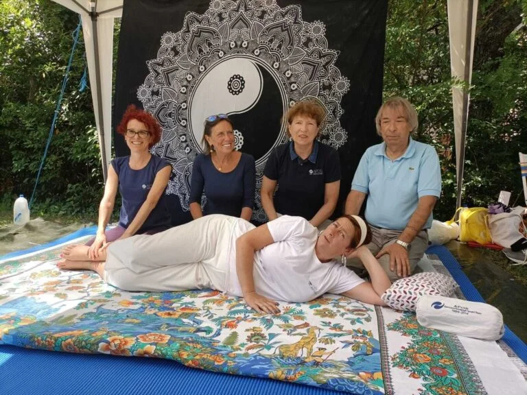 Group of happy operators posing with one of them lying down simulating a treatment